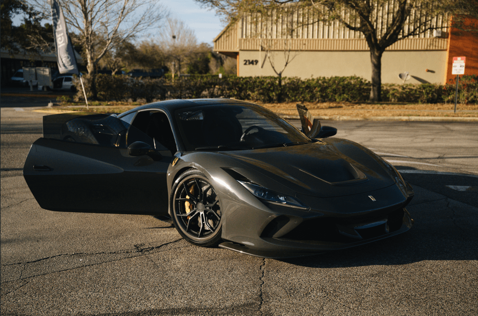 2020 Ferrari F8 Tributo parked with door open, showcasing sleek design and aerodynamic features.