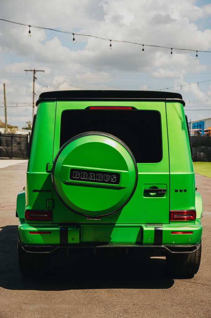 2022 Mercedes G63 AMG (Brabus Kit) in vibrant green, showcasing its unique Brabus design and rear view.