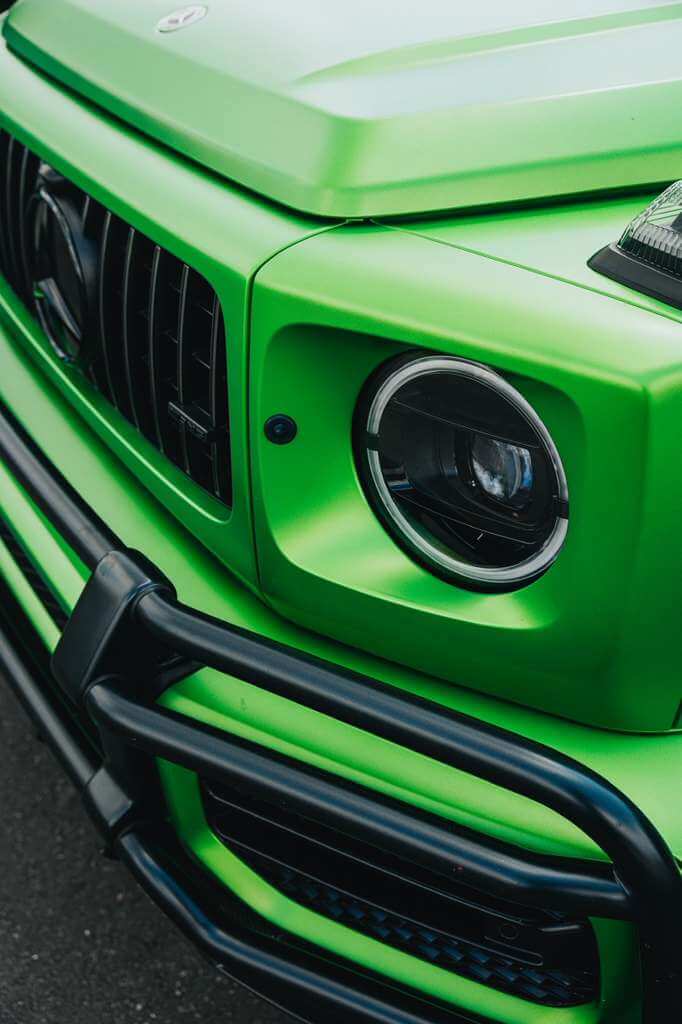Close-up of the front detail of a vibrant green 2022 Mercedes G63 AMG (Brabus Kit), showcasing premium design.