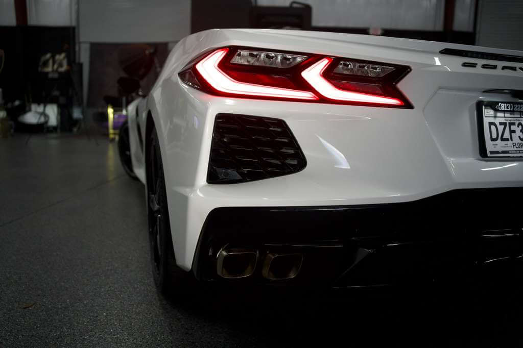 2023 Corvette C8 rear view in Arctic White showcasing its sleek design and distinctive taillights.