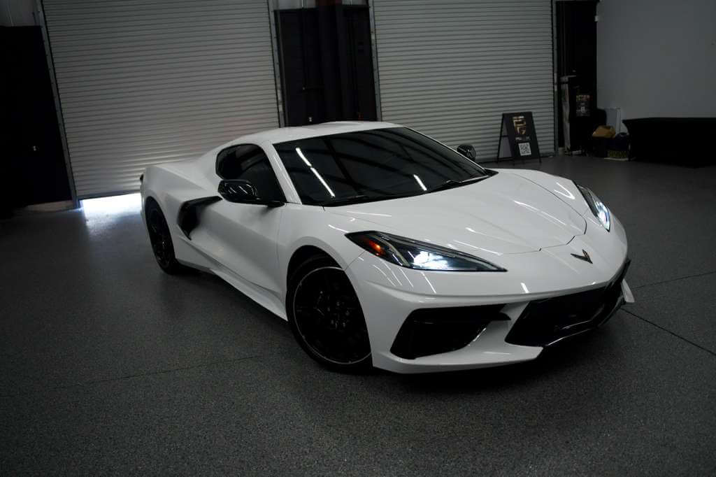 2023 Corvette C8 in Artic White parked indoors at Royal International Cars.