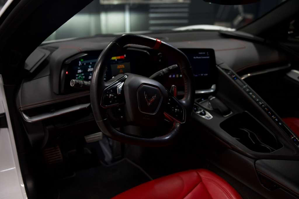 Interior view of the 2023 Corvette C8 showcasing the sleek dashboard and red leather seats.