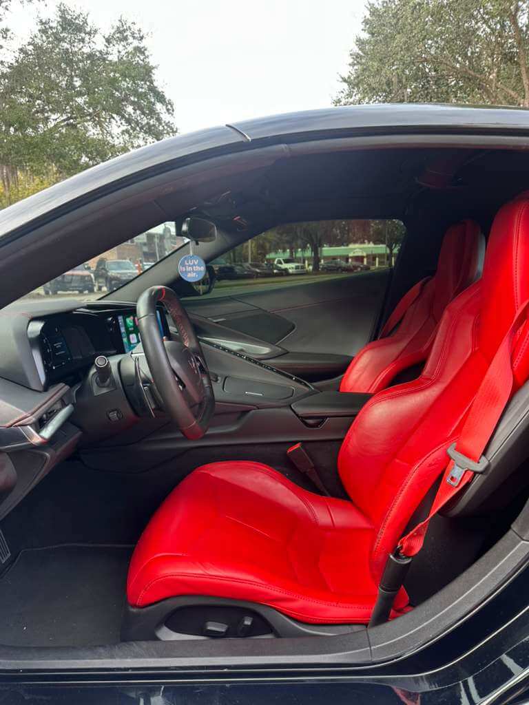 Interior of the 2023 Corvette C8 featuring red leather seats and a modern dashboard.