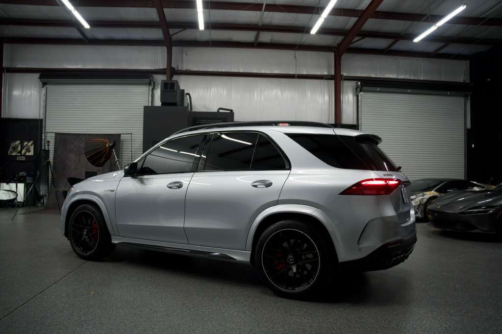 2024 Mercedes GLE 63S side view in a modern garage, showcasing luxury design and sleek performance.