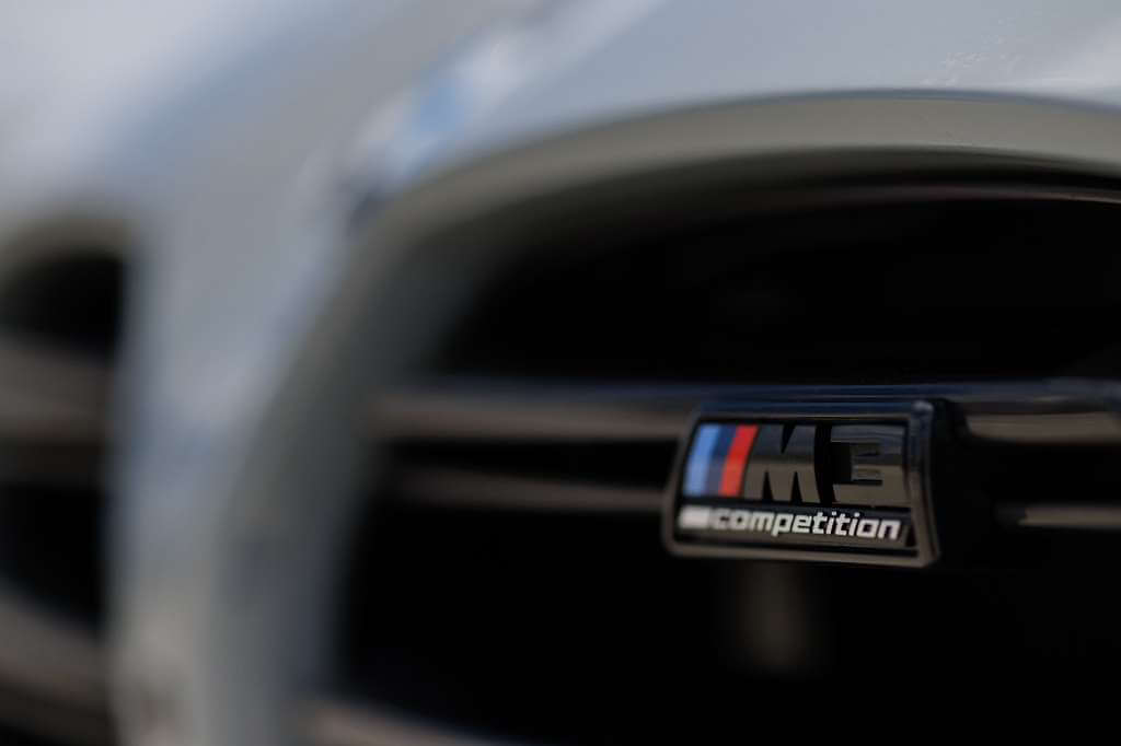 Close-up of the 2026 BMW M3 Competition badge on the grille, showcasing luxury performance.