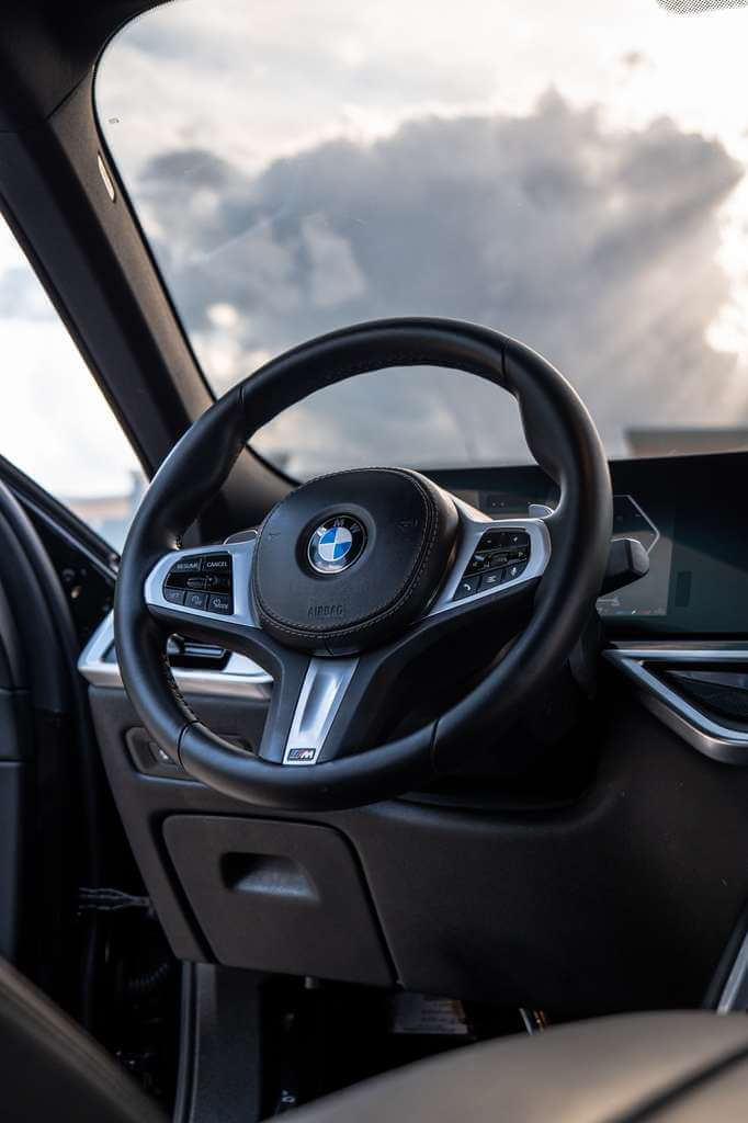 2026 BMW X6 interior view featuring the sleek steering wheel and dashboard.
