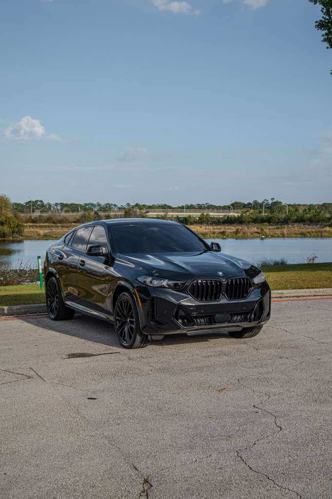 2026 BMW X6 parked near a lake in Orlando, showcasing its luxury SUV design.