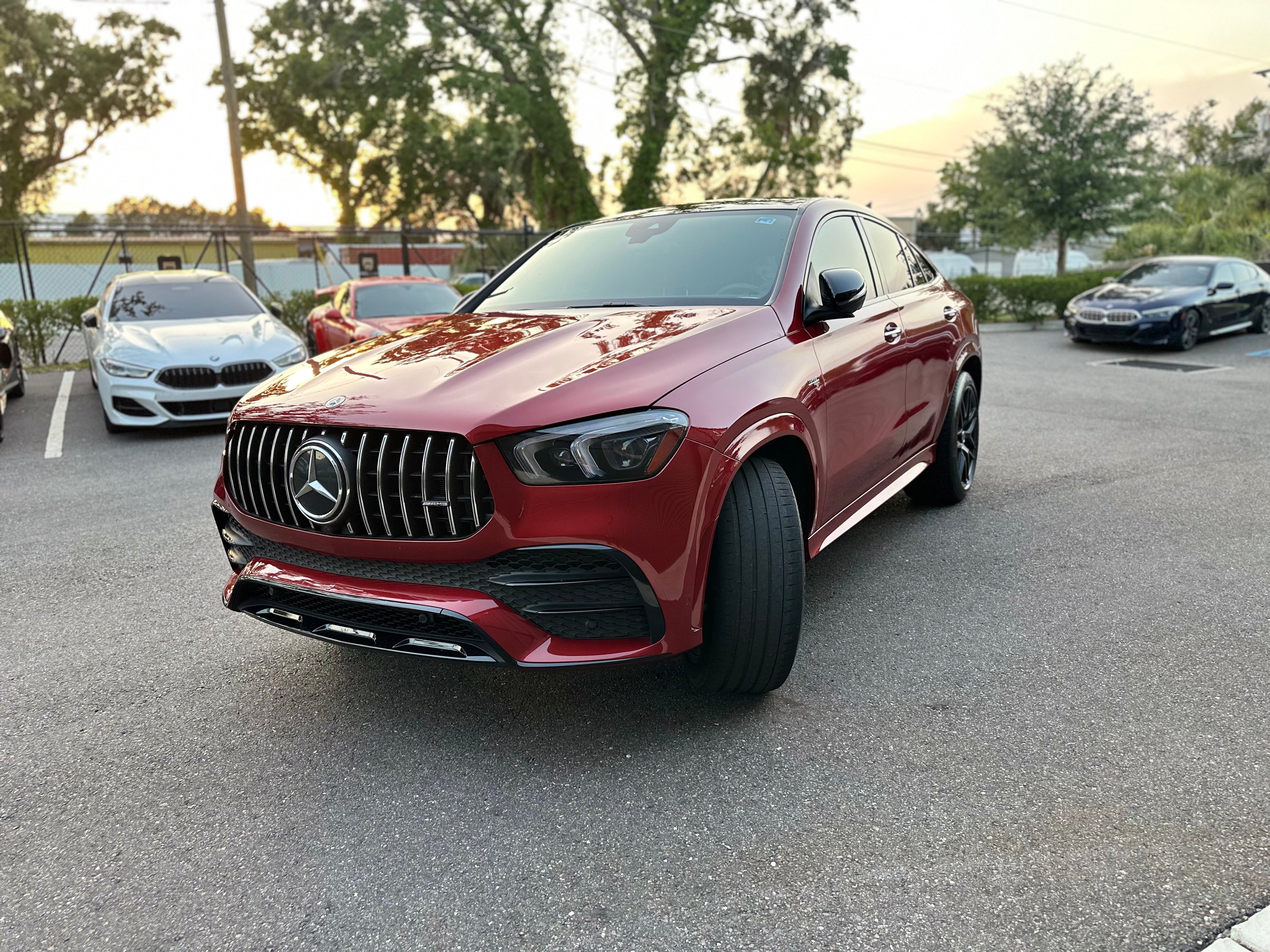 Red Mercedes-Benz AMG SUV with black grille and sporty design parked outdoors, luxury performance crossover vehicle.