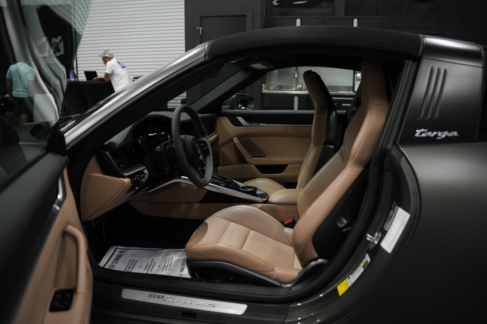 Interior view of Porsche 911 Targa 4S with beige leather seats and modern dashboard, luxury sports car cockpit with premium features.