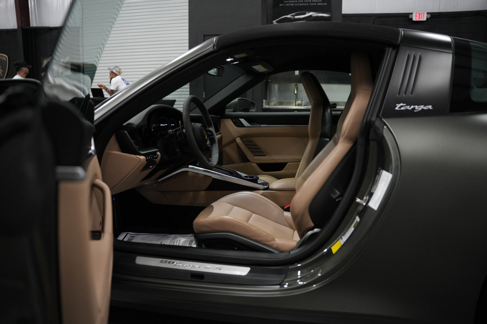 Interior view of a luxury Porsche 911 Targa 4S sports car with tan leather seats and sleek dashboard, showcasing premium design and comfort.