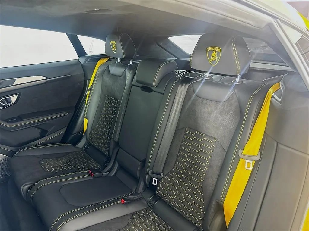 Black and yellow Lamborghini rear leather seats with detailed stitching and branded headrests, luxury sports car interior upholstery.