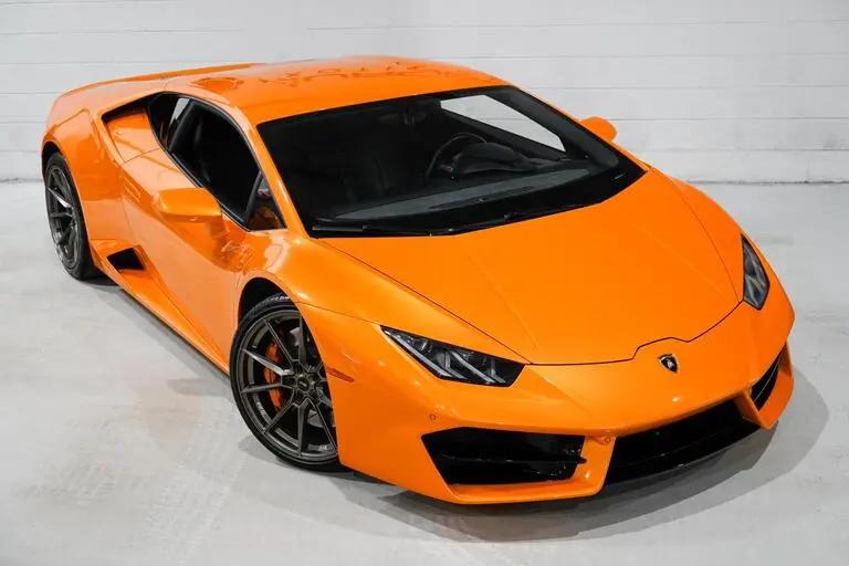 Orange Lamborghini Huracan sports car with black alloy wheels, sleek aerodynamic design, and luxury performance features.