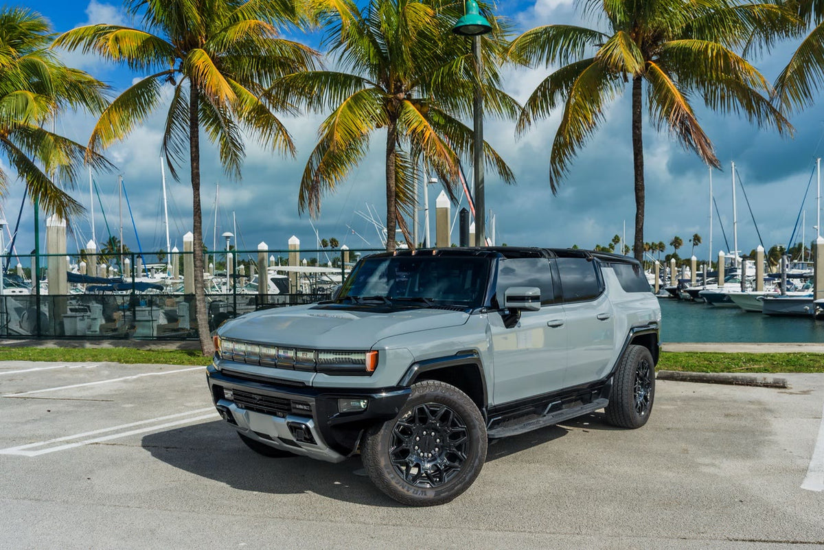 GMC Hummer EV SUV front three-quarter view with the full-width illuminated grille
