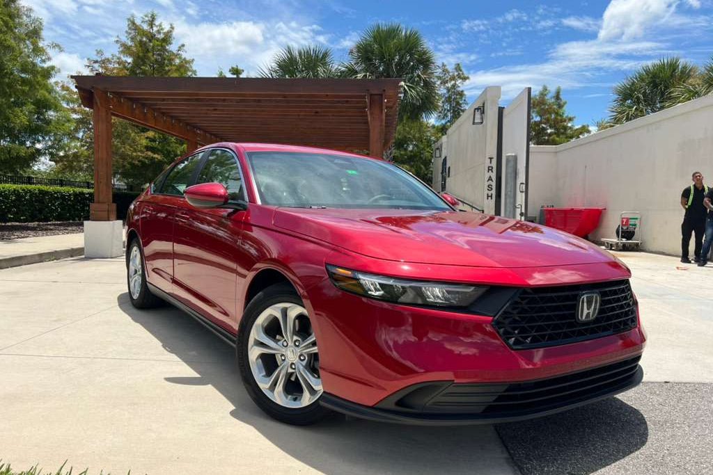 Red 2023 Honda Accord sedan with sleek design, LED headlights, and alloy wheels parked outdoors under blue sky perfect for reliable fuel-efficient family car.