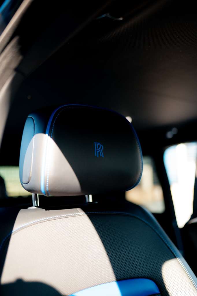 Luxury black leather car seat headrest with blue stitching and Rolls ...